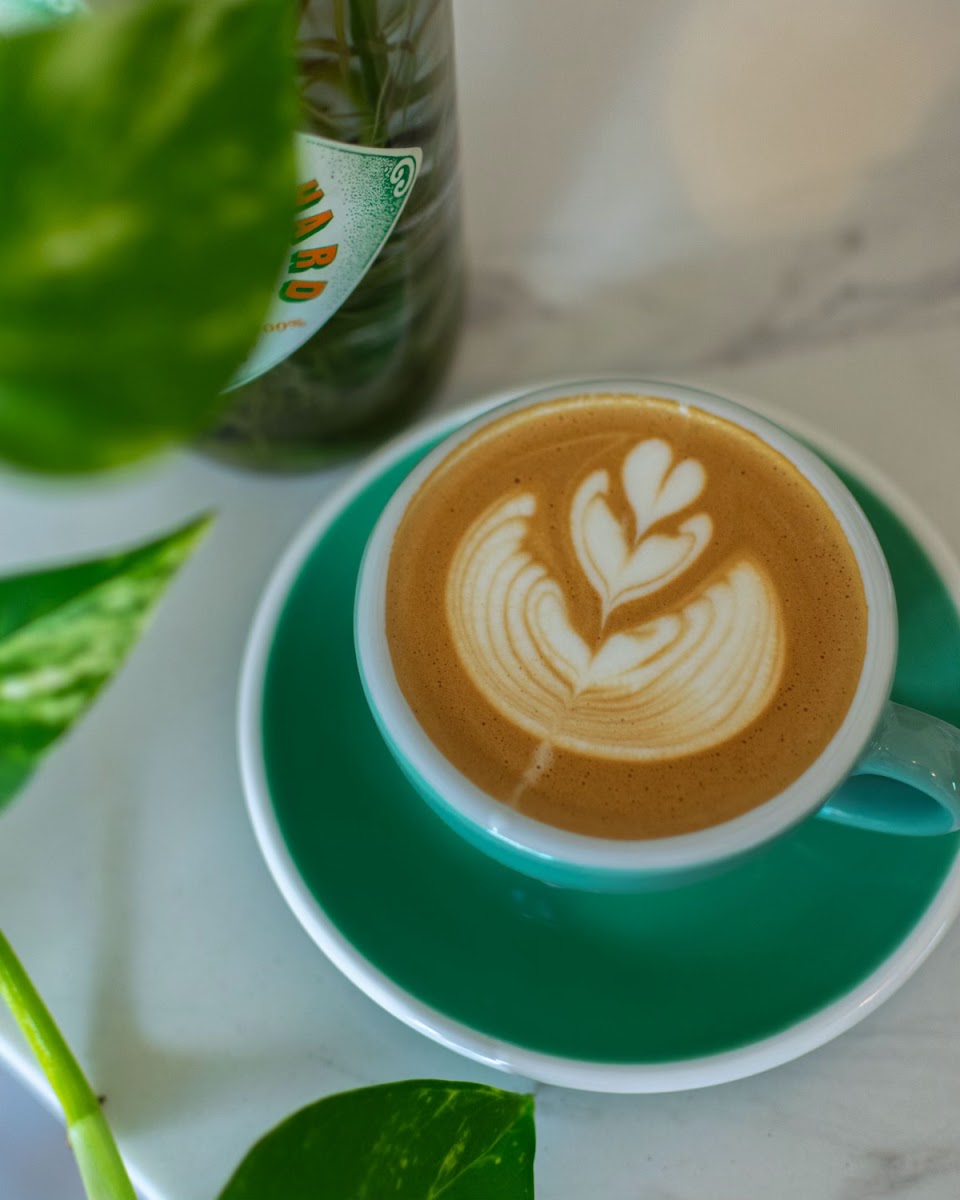 Coffee at Pilar Cafe & Eatery served on a green saucer